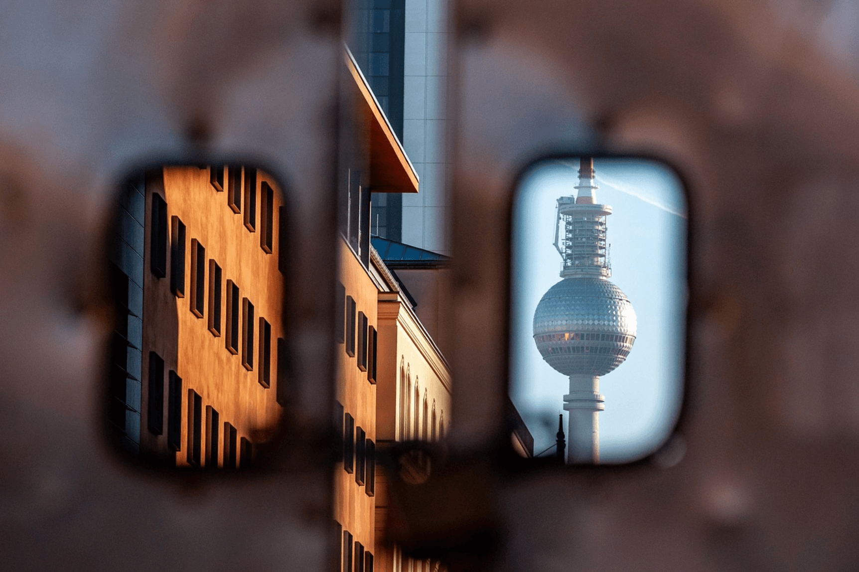 La Fernsehturm di Berlino riflessa tra i palazzi al tramonto
